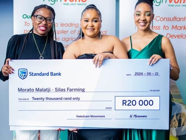 Three women stand together holding a large check for R20,000 from the StandardBank AgriVuno Agriculture Women in Agri Accelerator Program, awarded to Morato Malatji - Silas Farming on 21 June 2024.